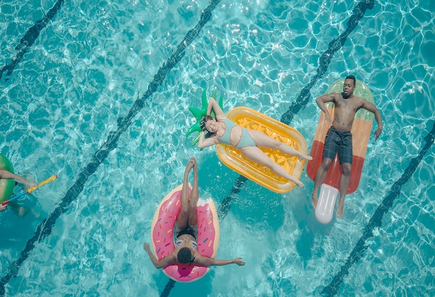Overhead view of friends in a pool on floating chairs