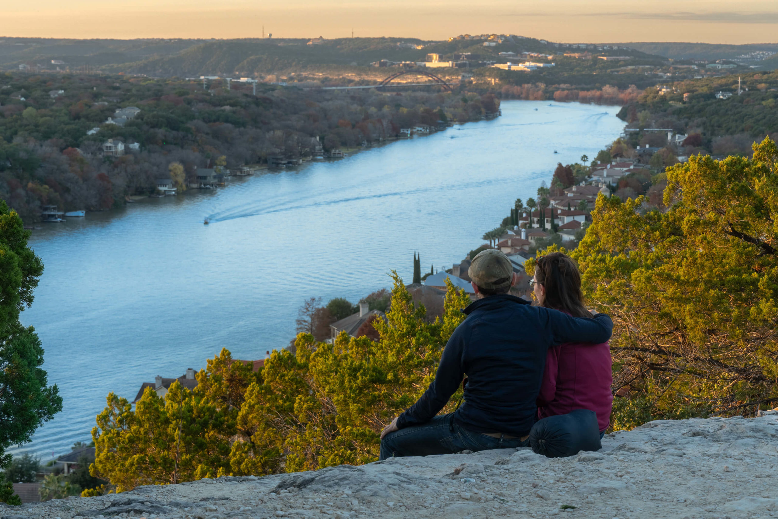 Couple on a hill overlooking a river.
