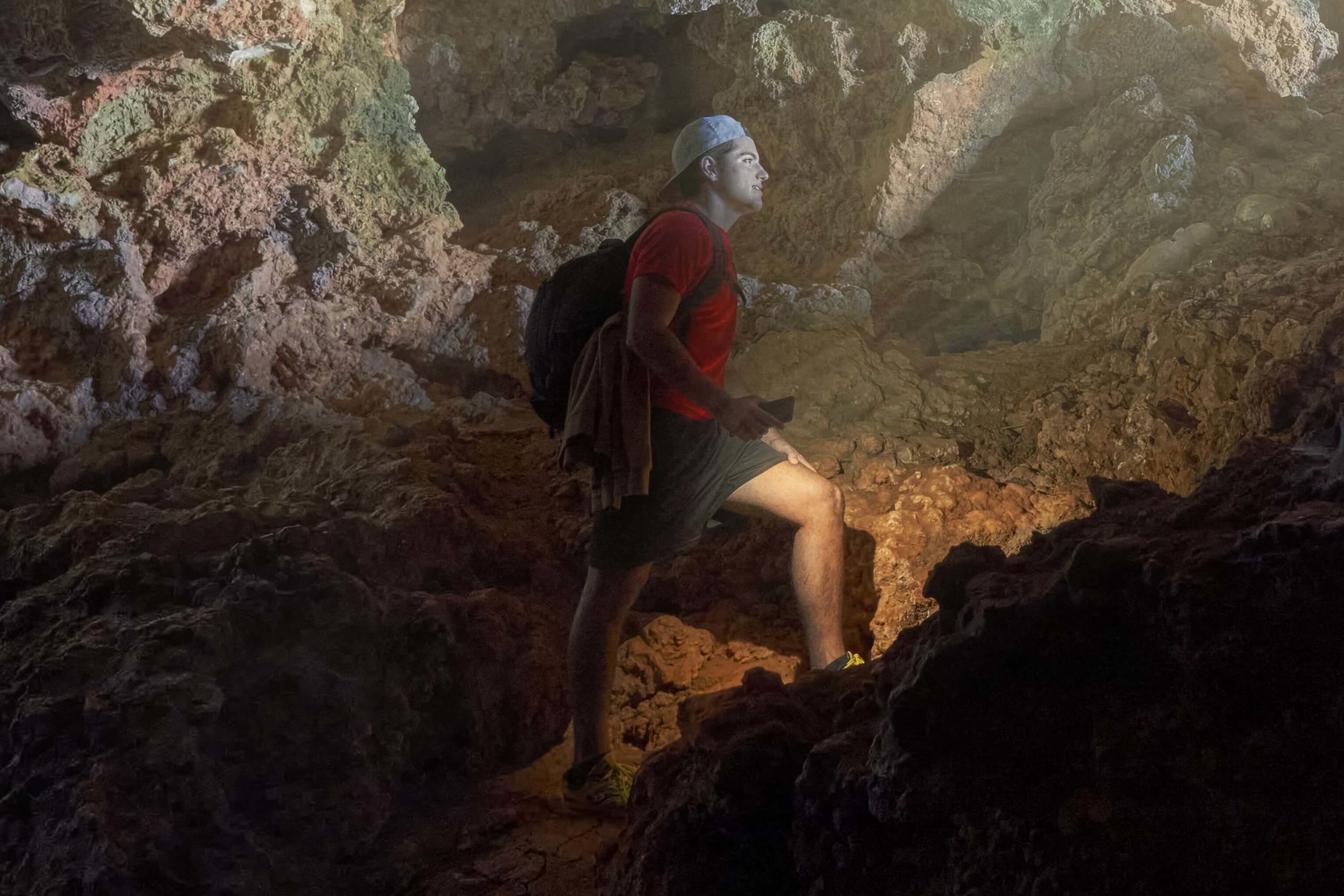 A man hiking through a cave in Texas Hill Country.